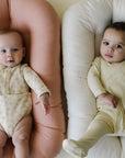 Two babies lying in loungers with Gumdrop pink and Natural covers