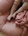 Close-up of baby feet on a Gumdrop pink organic cotton lounger cover