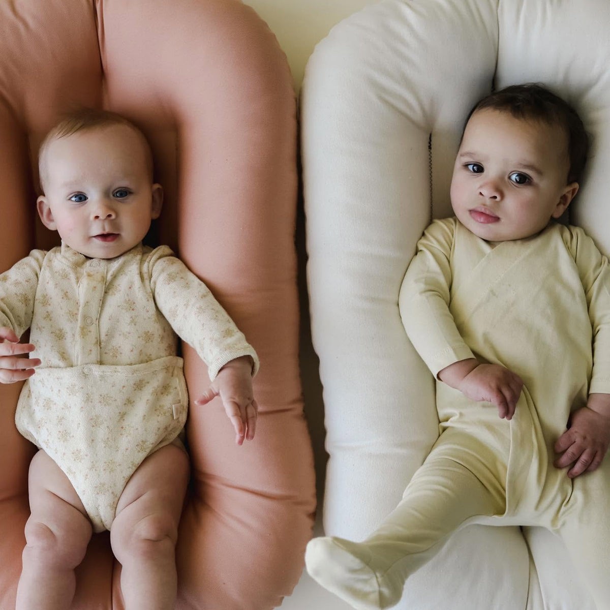 Two babies lying in loungers with Gumdrop pink and Natural covers