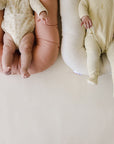 Babies' legs resting on Gumdrop and Natural organic lounger covers, top view