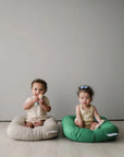 Two babies sitting side by side in Birch and Moss organic baby loungers